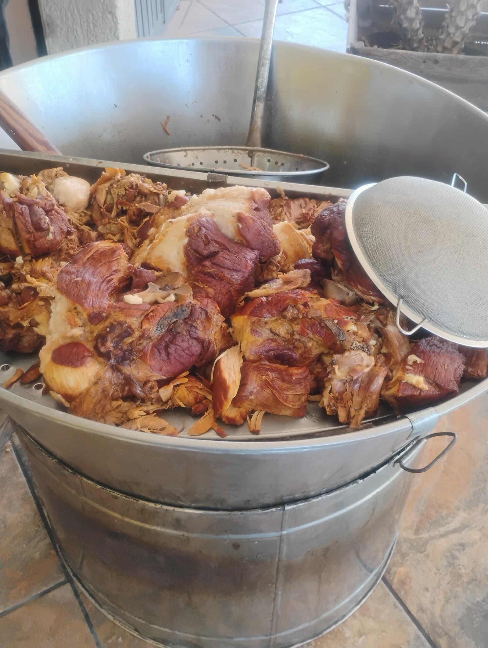 Trozos de chancho dorándose en cazo de acero