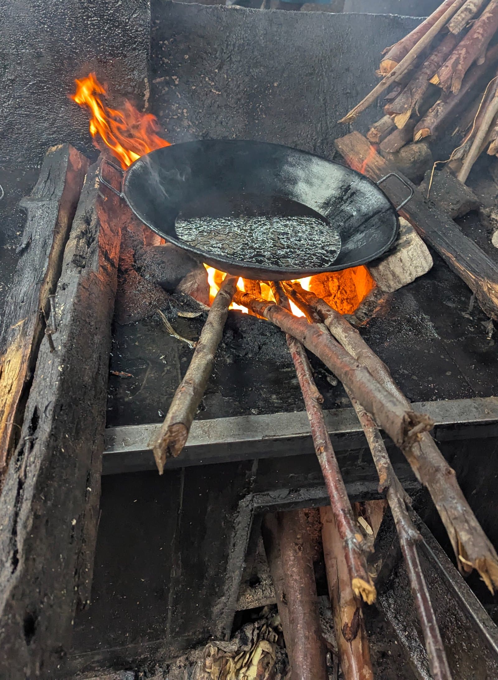 Paila de aceite calentándose sobre fuego de leña