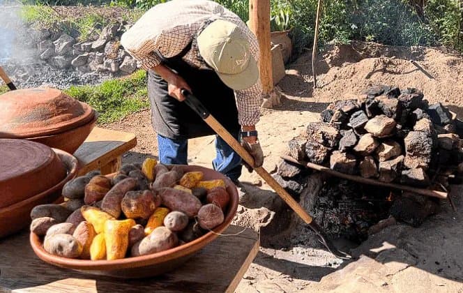 Armado del hoyo: piedras, carnes en panca, papas nativas y humitas